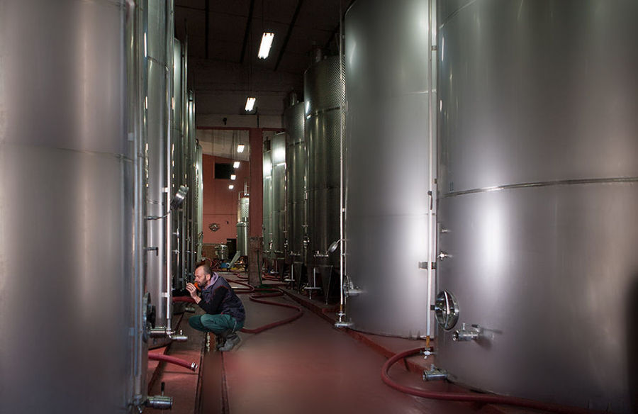 man doing maintenance work of wine tanks at 'Zoinos Winery' plant